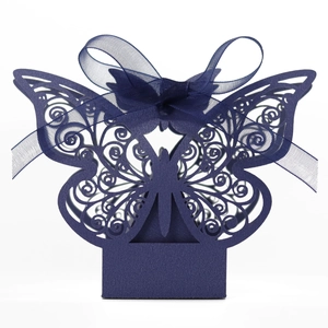 Macro detail of navy blue laser-cut butterfly favor box with elegant satin ribbon bow