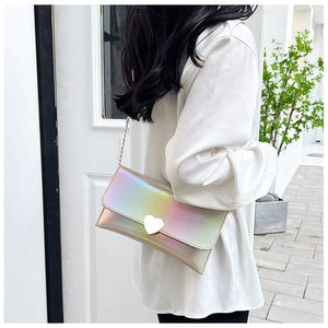 Detail of laser iridescent heart purse with gold chain strap and heart-shaped metal clasp