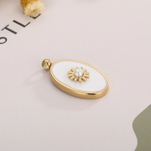 Detailed macro view of an oval gold pendant with central pearl and sunburst motif