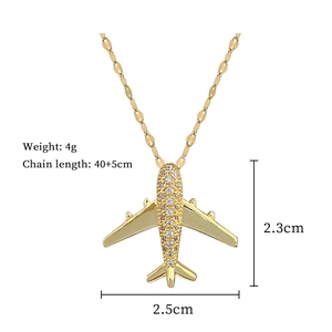 Close-up of gold airplane pendant with crystal pavé details and size dimensions