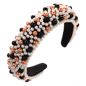 Détail du serre-tête en éponge orné de perles blanches et or rose de tailles variées sur velours