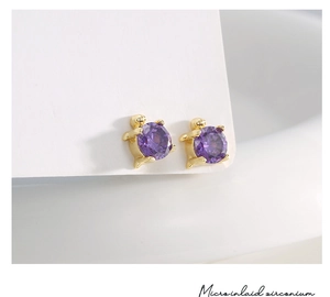 Macro shot of gold-plated turtle earrings featuring micro-inlaid purple round zircon stone