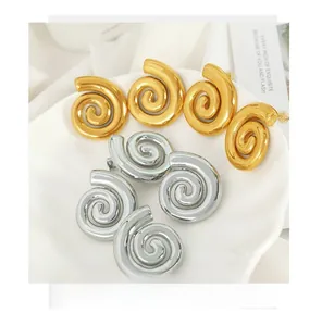 Detailed view of snail shell spiral earrings in polished gold and silver finishes