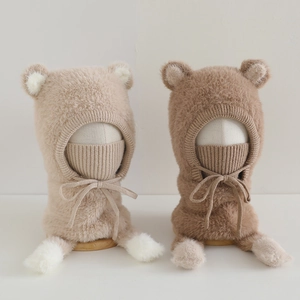Detail of plush bear ear balaclava hats in beige and brown for winter wind protection