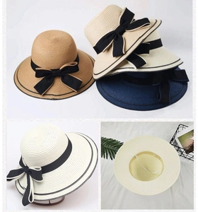 Detail view of straw sun hat featuring adjustable wind rope and black ribbon bow