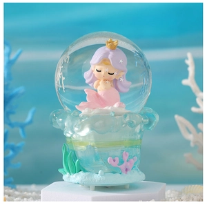 Detail of mermaid snow globe night light with pink tail and coral reef decor