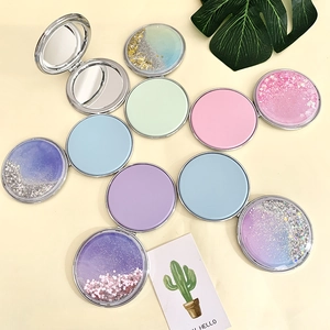 Flat lay of colorful glitter sand handheld compact makeup mirrors in various pastel colors
