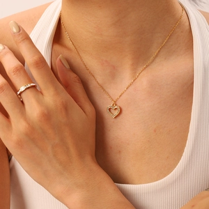Detail of 18K gold plated heart pendant necklace and matching ring with sparkling zircons