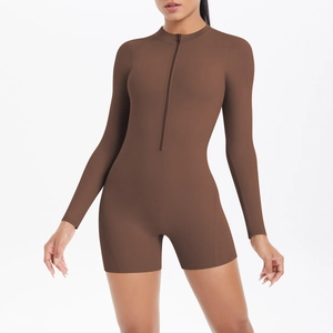 Detail of a brown long-sleeved athletic jumpsuit featuring a front zipper and stand collar