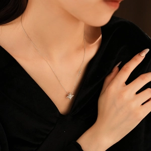 Détail d'un collier avec pendentif étoile à quatre branches en argent sur un mannequin