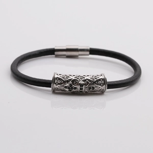 Detail of gothic silver cross cylinder charm on black leather rope bracelet for men