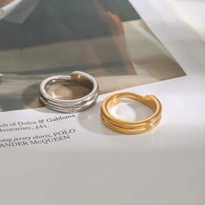 Minimalist double-layered 18K gold and silver stainless steel rings on a fashion magazine