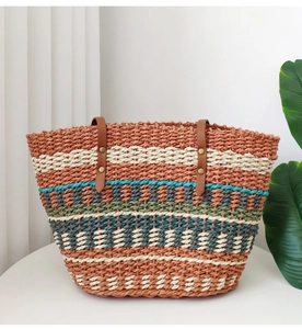 Close-up of rainbow woven straw tote with premium brown leather handles and metal rivets