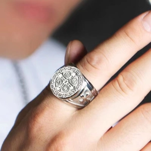 Detailed view of Saint Benedict vintage titanium steel ring on male finger