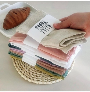 Close-up of stacked waffle weave cotton napkins in assorted neutral tones on a table