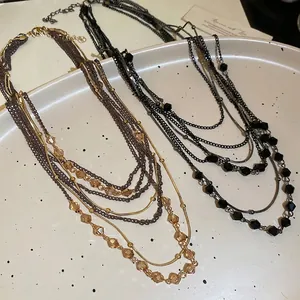 Bohemian multi-layer crystal beaded necklaces in amber and black styles on white tray