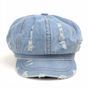 Distressed blue denim newsboy cap with vintage washed finish and brown stitching details