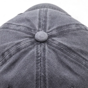 Detailed top view of a washed grey cotton baseball cap showing button and stitching