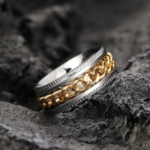 Macro shot of industrial style spinning ring with gold curb chain and silver band