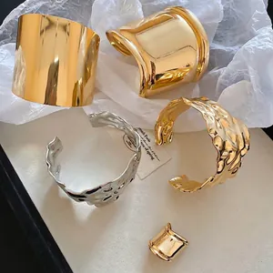 Polished chunky gold and silver cuff bracelets with irregular hammered texture design