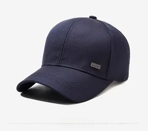 Detail of navy blue cotton baseball cap featuring reinforced stitching and metal side badge