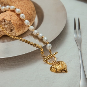 Detail of 18K gold heart pendant with freshwater pearls and elegant T-bar toggle clasp