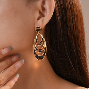 Detail of layered gold oval earrings with leopard print faux fur texture on model