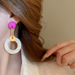 Close-up of geometric acrylic earrings with marble texture on a model's ear