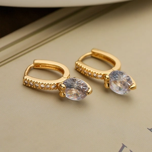Macro shot of gold plated geometric earrings with round zircon and pavé accents