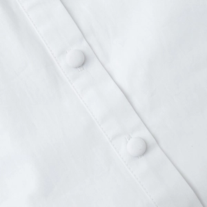 Détail de la robe dos nu blanche avec boutons recouverts de tissu et coutures précises