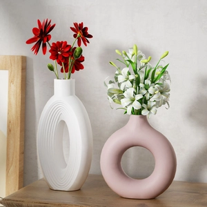 Detail of white oval and pink donut vases with relief texture for home decor