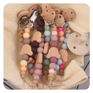 Detailed macro of beech wood bear pacifier clips and soft silicone teething beads