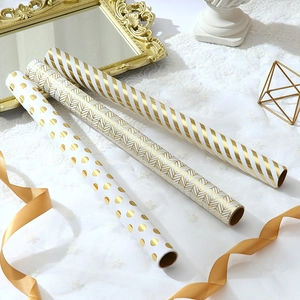 Gold foiled striped and polka dot gift wrapping paper rolls for luxury holiday presents