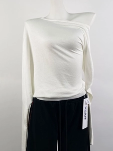 Detail of white off-shoulder knit top with fine texture and SPAY branded tag