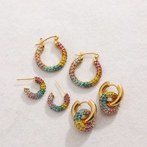 Macro view of three pairs of 18K gold plated hoop and stud earrings with rainbow crystals