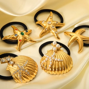 Gold starfish and seashell hair ties set with rhinestones on champagne silk background