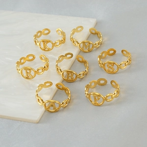Detail view of gold titanium steel alphabet rings with adjustable open band design