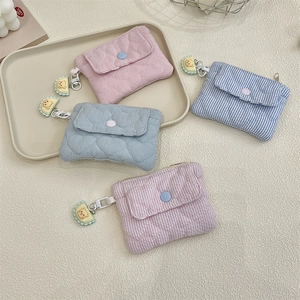 Quilted floral coin purses with bear pendants on a beige aesthetic background