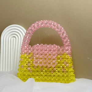 Detailed macro of pink and yellow handmade beaded bag on luxury silk background