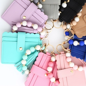 Top view of colorful PU leather card holders with silicone bead bracelets and tassels