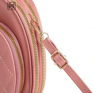 Macro view of light pink quilted round bag with premium gold zipper and stitching detail