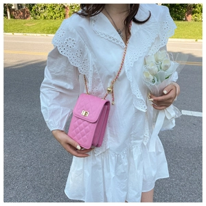 Pink quilted leather mini crossbody phone bag shown on model in street setting