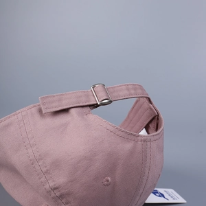 Détail de la boucle métallique ajustable et des coutures sur une casquette en coton