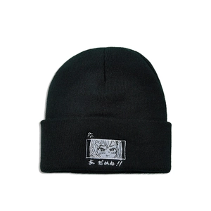 Detail of black knit beanie featuring Japanese anime style eye embroidery and text