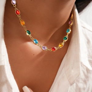 Close-up of a colorful resin oval necklace with a golden chain on a white shirt model