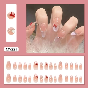Pink blush cat-eye gradient press-on nails with red bows, pearls and glitter accents