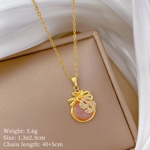 Macro view of gold lucky money bag pendant with pink stone and cz details on silk