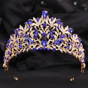 Detail of baroque crown showing golden leaf patterns with blue crystals and gems
