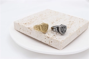 Macro detail of retro shield rings with knight cross pattern in gold and silver finish