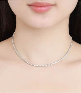 Close-up of 2mm moissanite bubble tennis necklace in sterling silver on a woman's neck